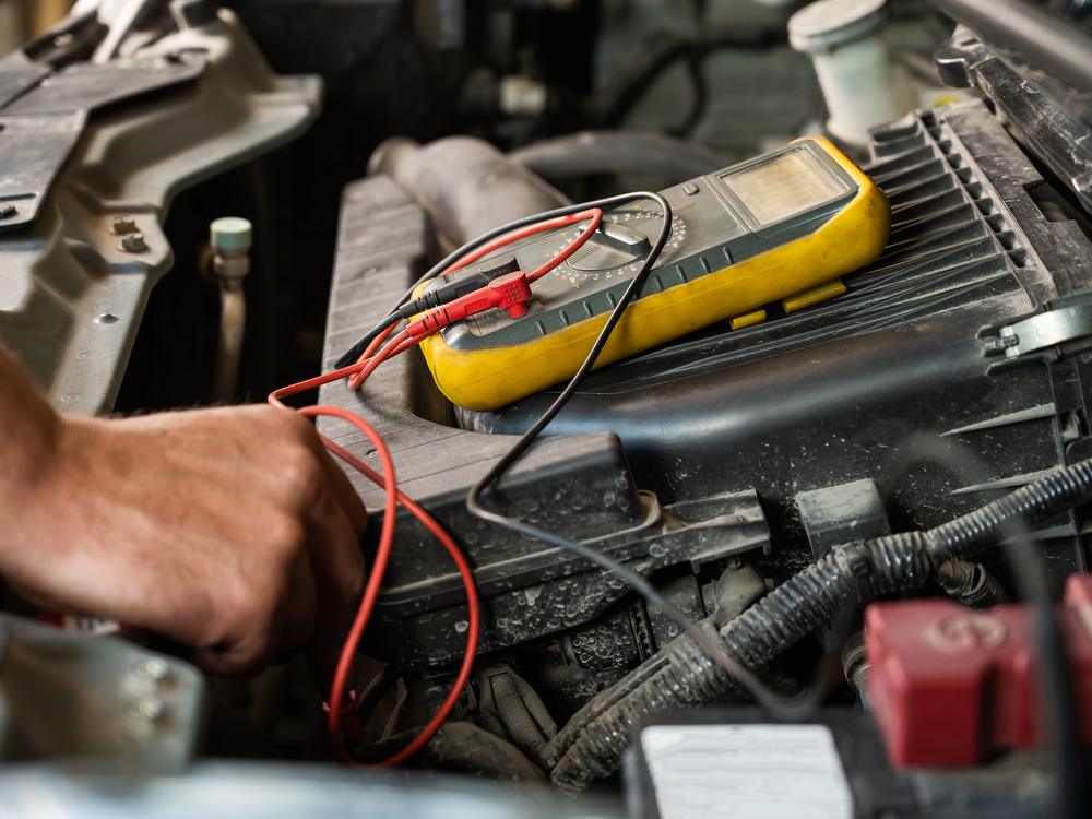 Technician testing an engine circuit with a multimeter